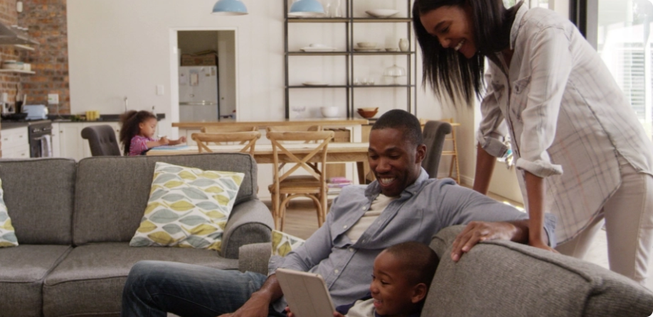 Famille assise sur un sofa utilisant l’outil Épargne et retraite sur un ordinateur portable