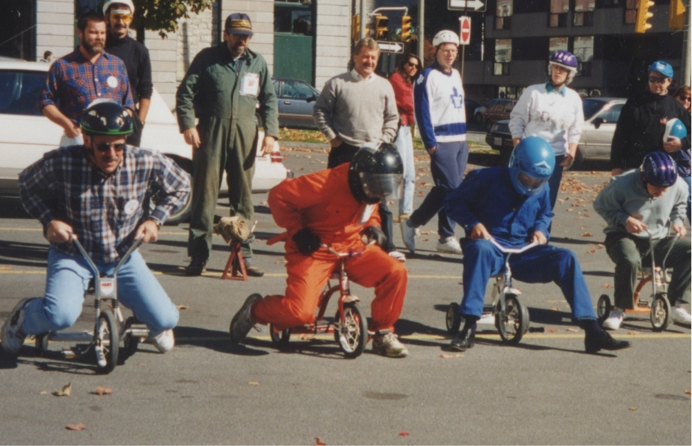 Archive photo showing Empire Life employees on mini tricycles for a charity event
