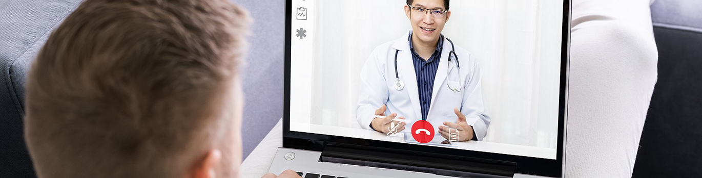 Homme assistant à une vidéoconférence avec son médecin sur son ordinateur portable