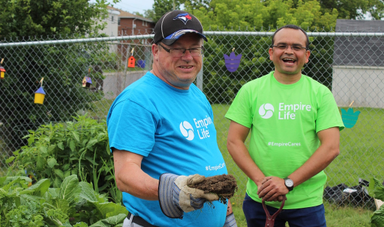 Two employees helping out with gardening on a local Day of Caring for United Way